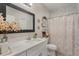 Well-lit bathroom with a decorative mirror, flower accents, and marble-look tile surround at 146 E 15Th St, Apopka, FL 32703