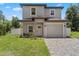 Charming two-story home with a well-maintained front yard and a brick-paved driveway leading to the garage at 146 E 15Th St, Apopka, FL 32703