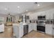 Modern kitchen features stainless steel appliances, white cabinets, quartz counters, and an open view into the living area at 146 E 15Th St, Apopka, FL 32703