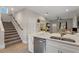 Modern kitchen with a quartz countertop island, stainless steel appliances, and an open staircase nearby at 146 E 15Th St, Apopka, FL 32703