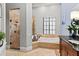 Bathroom boasting a soaking tub, walk-in shower, dark wood vanity, and marble tile at 14724 Avenue Of The Rushes, Winter Garden, FL 34787
