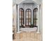 Bathtub with arched window, plantation shutters, marble surround and columns, for natural light and style at 14724 Avenue Of The Rushes, Winter Garden, FL 34787