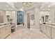 Elegant bathroom featuring dual vanities, a chandelier, and a large soaking tub beneath arched windows at 14724 Avenue Of The Rushes, Winter Garden, FL 34787