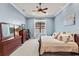 Cozy bedroom featuring a large bed with decorative pillows, wooden furniture, and a ceiling fan at 14724 Avenue Of The Rushes, Winter Garden, FL 34787