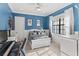 Bright bedroom featuring blue walls, a white bed frame, and large windows letting in natural light at 14724 Avenue Of The Rushes, Winter Garden, FL 34787