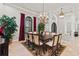 Elegant dining room featuring a large table, chandelier, and arched windows with red curtains at 14724 Avenue Of The Rushes, Winter Garden, FL 34787