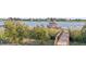 Charming dock with a gazebo on a tranquil lake, bordered by lush vegetation and neighborhood homes at 14724 Avenue Of The Rushes, Winter Garden, FL 34787