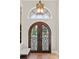 Elegant entryway featuring decorative iron double doors, a transom window, and stylish lighting at 14724 Avenue Of The Rushes, Winter Garden, FL 34787