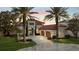 Elegant stucco home features a red tile roof, arched windows, lush landscaping and a circular driveway at 14724 Avenue Of The Rushes, Winter Garden, FL 34787