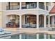 Luxury home with an outdoor kitchen, poolside seating, and expansive windows for natural light at 14724 Avenue Of The Rushes, Winter Garden, FL 34787
