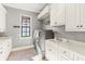 Bright laundry room with modern washer/dryer, a utility sink, and ample cabinet space at 14724 Avenue Of The Rushes, Winter Garden, FL 34787