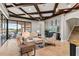 Open living room with beamed ceiling, tile floors, comfortable seating, and a view of the pool and lake at 14724 Avenue Of The Rushes, Winter Garden, FL 34787