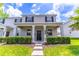 Charming two-story home featuring a covered porch, gray stucco, and lush, landscaped front yard at 15030 Book Club Rd, Winter Garden, FL 34787