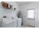 Bright laundry room with white washer/dryer, utility sink, and access to the exterior at 15030 Book Club Rd, Winter Garden, FL 34787