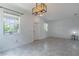 Bright living room showcasing neutral walls, modern light fixture, and tile floors for a clean aesthetic at 15030 Book Club Rd, Winter Garden, FL 34787