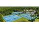 Community aerial featuring a basketball court, tennis courts, and clubhouse amidst a lush green landscape at 1902 Hailsham Ct, Orlando, FL 32824