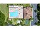 Aerial view of the community clubhouse and pool area, featuring ample seating, mature trees, playground, and parking at 1902 Hailsham Ct, Orlando, FL 32824