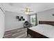 Cozy bedroom with wood-look floors, ceiling fan, a large window, and dark wood furnishings at 1902 Hailsham Ct, Orlando, FL 32824
