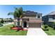 Inviting two-story home with a well-manicured lawn, solar panels, and an attached two-car garage at 1902 Hailsham Ct, Orlando, FL 32824