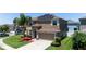 Inviting two-story home with a well-manicured lawn, solar panels, and an attached two-car garage at 1902 Hailsham Ct, Orlando, FL 32824