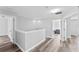 Upstairs hallway featuring wood-look flooring, white trim, and bedroom doorways at 1902 Hailsham Ct, Orlando, FL 32824