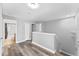 Upstairs hallway featuring wood-look flooring, white trim, and bathroom and bedroom doorways at 1902 Hailsham Ct, Orlando, FL 32824