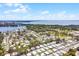 An aerial view showcases a sprawling residential community near a beautiful lake, with mature trees and sunny skies at 200 Palm Meadows Dr, Eustis, FL 32726