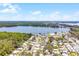 An aerial view capturing a charming community near a serene lake, surrounded by lush greenery and clear skies at 200 Palm Meadows Dr, Eustis, FL 32726