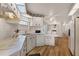 White kitchen with wood-look flooring and white appliances, cabinets, and countertops, plus vintage floral wallpaper border at 200 Palm Meadows Dr, Eustis, FL 32726
