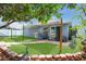 Serene backyard featuring a covered patio, seating area, outdoor grill, and lush artificial turf at 204 Bay Meadow Dr, Kissimmee, FL 34746