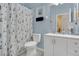 Light blue bathroom with a white vanity, toilet and a shower with a sailboat curtain at 204 Bay Meadow Dr, Kissimmee, FL 34746