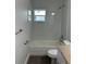 Bathroom featuring a tiled bathtub, a low window, and a white toilet at 205 Brighton Way, Casselberry, FL 32707