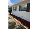 Side view of home with black shutters, manicured mulch and a water hose at 205 Brighton Way, Casselberry, FL 32707