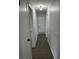 Hallway with light gray walls and gray-brown vinyl flooring leading to an access panel door at 205 Brighton Way, Casselberry, FL 32707