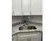Close-up of a stylish stainless steel kitchen sink with granite countertops and white cabinets at 205 Brighton Way, Casselberry, FL 32707