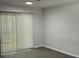 Light and airy living room with sliding glass doors and vertical blinds and gray walls at 205 Brighton Way, Casselberry, FL 32707