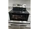 Stainless steel electric range with a black cooktop and knobs over the open oven at 205 Brighton Way, Casselberry, FL 32707