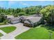 Aerial view of a home with manicured lawn, brick driveway, and mature trees at 2106 Tuscarora Trl, Maitland, FL 32751