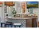 Indoor bar featuring a mosaic tile front, granite countertop, and a variety of liquor bottles at 2106 Tuscarora Trl, Maitland, FL 32751