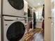 Walk-in closet with custom shelving, hanging rods, and stacked washer and dryer at 2106 Tuscarora Trl, Maitland, FL 32751