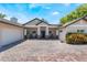 Charming single-story home featuring a brick driveway and covered front porch with a brick and tan exterior at 2106 Tuscarora Trl, Maitland, FL 32751