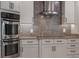 Kitchen features a stainless steel oven, glass range hood, stone backsplash, countertops and modern cabinets at 2106 Tuscarora Trl, Maitland, FL 32751