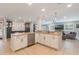 Open kitchen with stainless steel appliances, island with sink, and white cabinets, connecting to the living room at 2106 Tuscarora Trl, Maitland, FL 32751