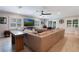 Bright living room with a large sectional sofa, ceiling fan, and a wall of windows for natural light at 2106 Tuscarora Trl, Maitland, FL 32751