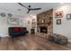 Inviting living room featuring a brick fireplace, hardwood flooring, and a contemporary futon at 2106 Tuscarora Trl, Maitland, FL 32751