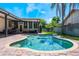 Swimming pool surrounded by a brick patio, with a covered seating area and lush green landscaping at 2106 Tuscarora Trl, Maitland, FL 32751
