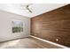 Bright bedroom featuring wood-look flooring, ceiling fan, and a decorative wood accent wall at 2125 Shackley Pl, Apopka, FL 32703
