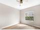 Inviting bedroom with light-colored walls, wood-look flooring, and a window overlooking the yard at 2125 Shackley Pl, Apopka, FL 32703