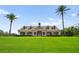 Stately clubhouse on a lush lawn, framed by towering palm trees, evoking a sense of luxury at 2125 Shackley Pl, Apopka, FL 32703