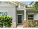Close-up view of the front door with stone pillar accent, neutral exterior, and manicured hedges at 2125 Shackley Pl, Apopka, FL 32703